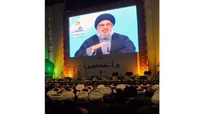 حسن نصر الله الأمين العام لحزب الله متحدثاً عبر شاشة تلفزيونية عملاقة في ذكرى المولد النبوي في بيروت (إ. بي. ايه)