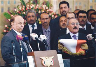 صالح (يمين) يقدم العلم اليمني للرئيس الجديد اثناء احتفال تسليم السلطة (رويترز)