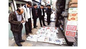 مواطنون إيرانيون في طهران أمام كشك لبيع الصحف التي ركزت عناوينها الرئيسية على الانتخابات البرلمانية المقررة اليوم (أ ف ب)