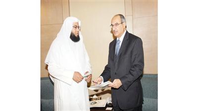السفير رشيد الحمد يسلم الشيك لمؤسسة المجمع الاسلامي الخيري