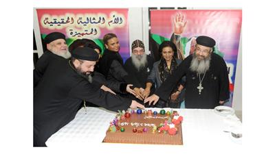 الشيخة فريحة الأحمد والقمص بيجول وعدد من الحضور يقطعون كيكة الاحتفال