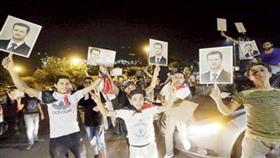 عدد من السوريين يحتفلون بفوز بشار الأسد في دمشق
(أ ف ب)