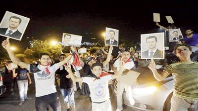عدد من السوريين يحتفلون بفوز بشار الأسد في دمشق
(أ ف ب)