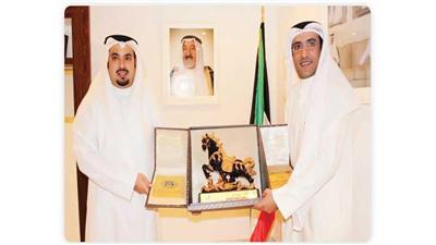 الشيخ خالد الأحمد يتسلم درع التكريم من د.فهد الهاجري