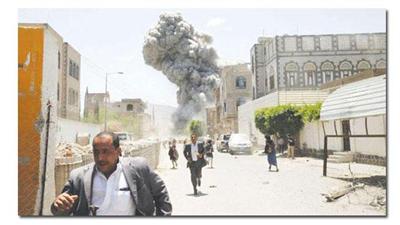 يمنيون يبتعدون عن منزل الرئيس السابق علي عبدالله صالح أثناء قصف قوات التحالف له أمس (رويترز)